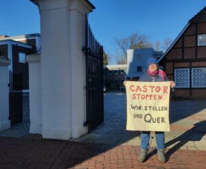 Eine Person hält ein Transparent "Castor stoppen - wir stellen uns quer"